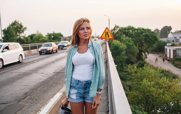 Yong mooie vrouw wandelen langs brug — Stockfoto