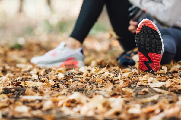 Runner woman rest on the leaves in park — Stock Photo, Image