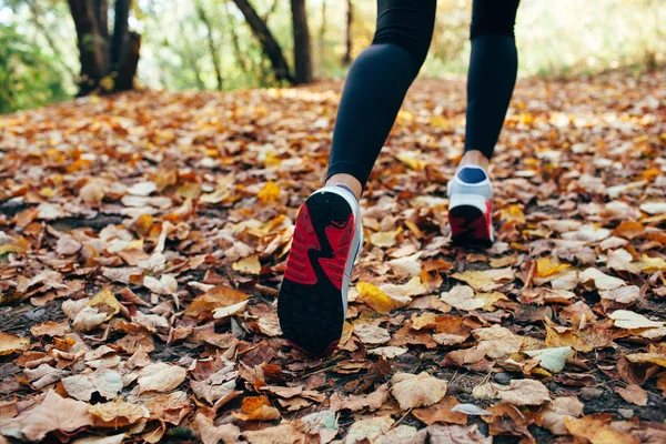 Woman runs for fall foliage, shoes closeup — Stock Photo, Image