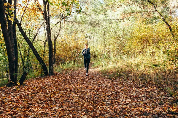 Läuferin joggt im Herbstpark — Stockfoto