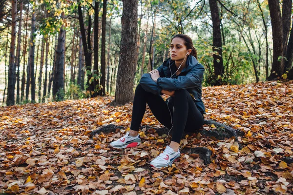 Runner vrouw rust op de bladeren in park — Stockfoto