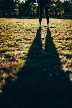 Spor avlusunda güneş karşı duran kadın