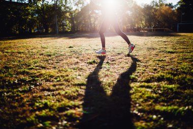 Spor avlusunda güneş karşı duran kadın