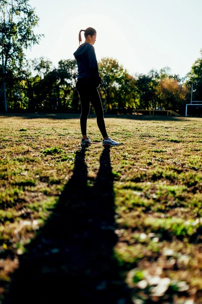 Woman standing on sport yard against the sun — Stock Photo, Image