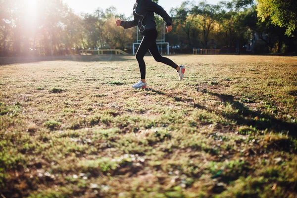 Frau steht auf Sportplatz gegen die Sonne — Stockfoto