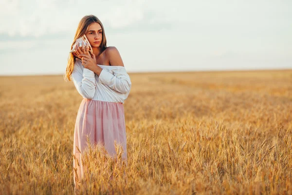 Schönes Mädchen im Weizenfeld bei Sonnenuntergang — Stockfoto