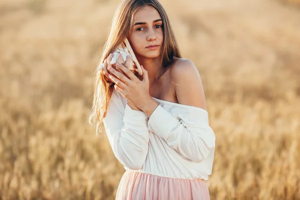 Красива дівчина в пшеничному полі на заході сонця — стокове фото