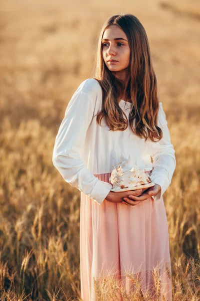 Vacker flicka i vete fält vid solnedgången — Stockfoto