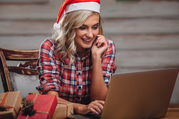 Blond kobieta kapeluszu, santa, praca z laptopem — Zdjęcie stockowe