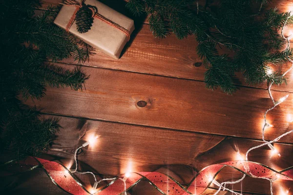 Scatola regalo e albero di pelliccia su sfondo di legno — Foto Stock