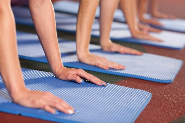 Les mains des femmes sont placées sur le tapis de gym — Photo