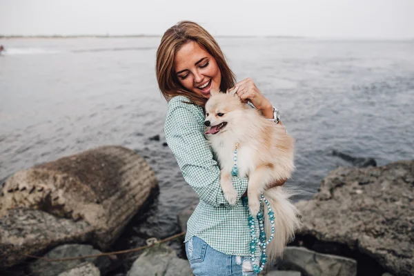 Jeune femme tient le chien à l'extérieur — Photo