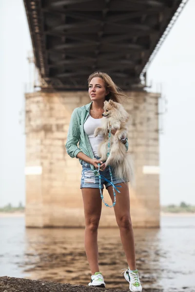 Jeune femme tient le chien à l'extérieur — Photo