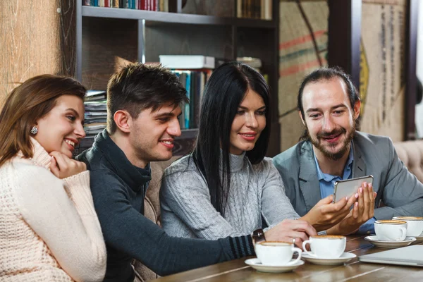 Groep vrienden met koffie en kijken naar smartphone — Stockfoto