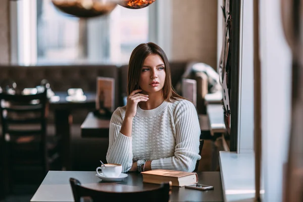 Kobieta siedzi w kawiarni, przy filiżance kawy — Zdjęcie stockowe