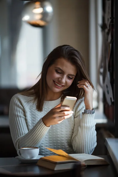 Vrouw met behulp van haar mobiele telefoon in café — Stockfoto