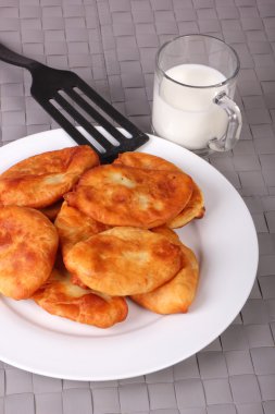 Kızarmış kek beyaz tabak, plastik spatula ve süt g fincan