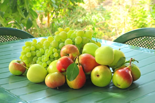 Druiven, appels en peren op een tafel — Stockfoto