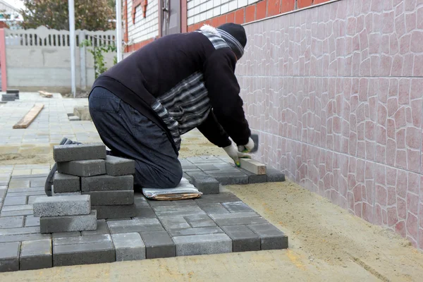Worker installs paving slabs — Stock Photo, Image
