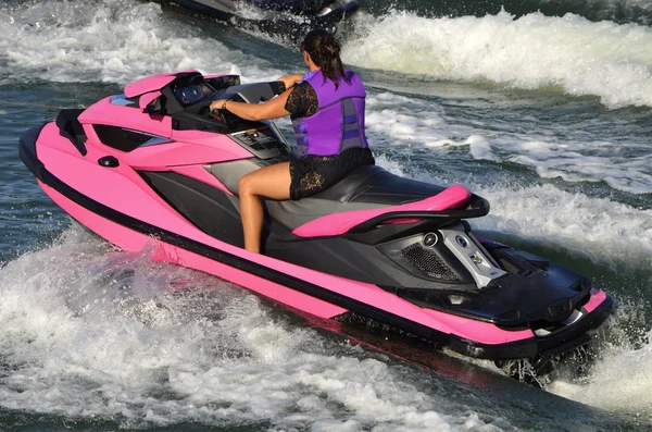 Mulher em um jet-ski-de-rosa chocante — Fotografia de Stock