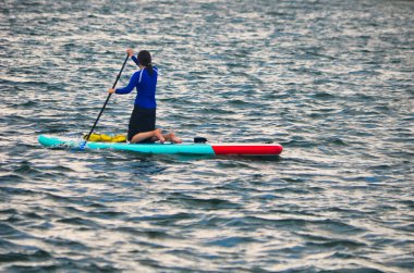 Miami Sahili 'nin dışındaki Florida' nın iç kıyılarında su yolunda şişme kürek çeken genç bir kadın..