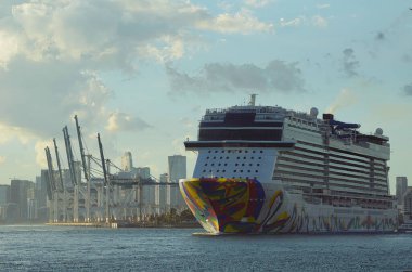 Boş bir konteynır iskelesinde vincin yanından geçen bir yolcu gemisi Miami 'den Karayip limanlarına giderken gökdelen manzarası..