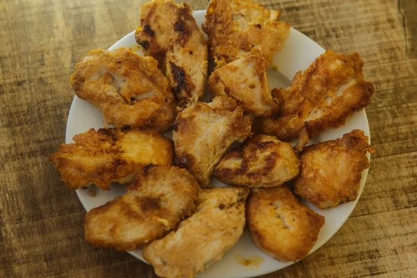 Κάτοψη τηγανιτά κομμάτια του κοτόπουλου που βρίσκεται στο άσπρο πιάτο — Φωτογραφία Αρχείου
