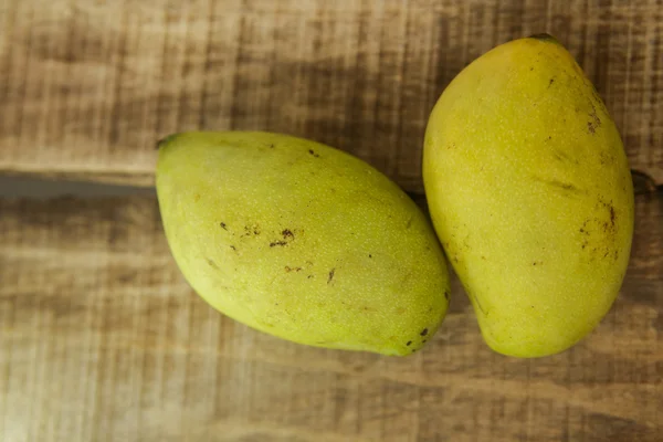 Fechar dois Mangos na mesa de madeira — Fotografia de Stock