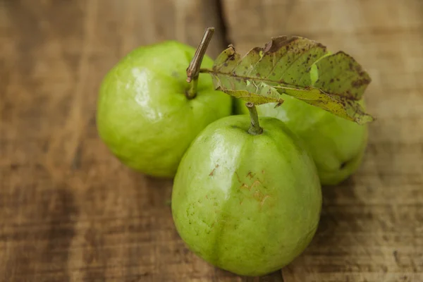 Nahaufnahme drei reife grüne Guaven auf braunem Tisch — Stockfoto