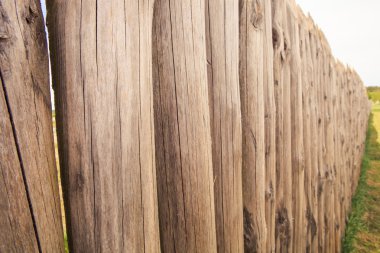 high old wooden fence of logs in form of palisade  clipart