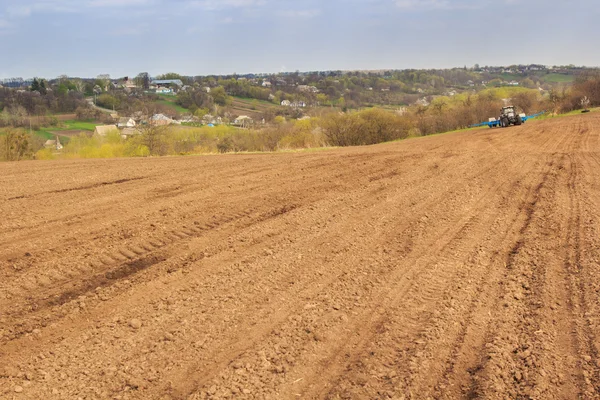 Traktor i plogad fältet av ukrainska Skogby på kullarna — Stockfoto