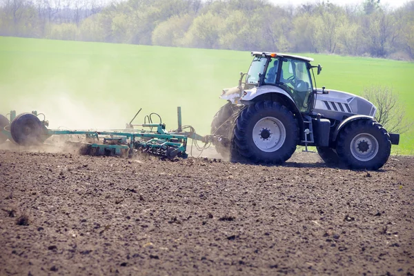 A nagy kerekek a felszántott mező zöld mező traktor — Stock Fotó