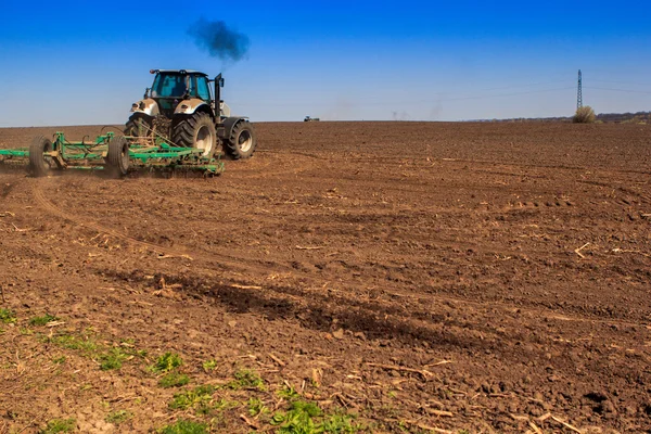 Вид сзади на посев тракторов в поле весной — стоковое фото