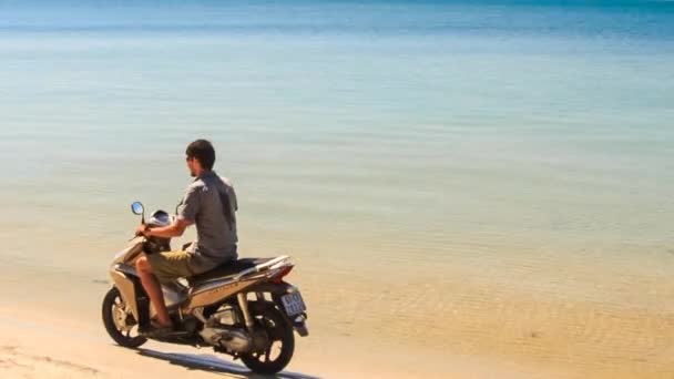 Man met scooter op het strand — Stockvideo