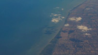 uçak penceresinden sahil ve gök mavisi deniz 