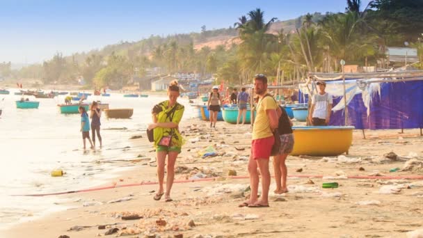 Toeristen op zee strand met vissersboten — Stockvideo