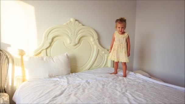 Lilla flickan hoppar på sängen — Stockvideo