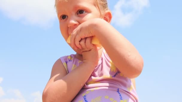 Little girl eats pineapple fruit — Stock Video