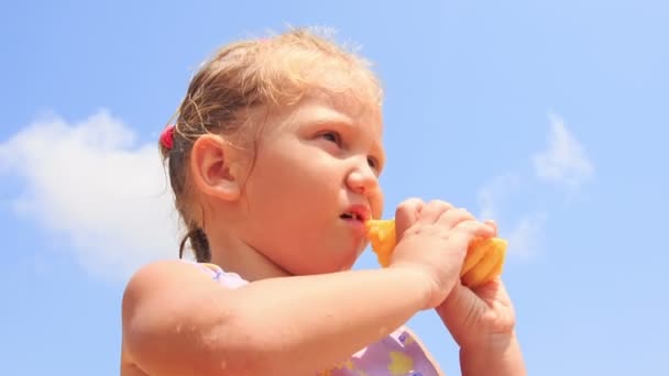 Little girl eats pineapple fruit — Stock Video