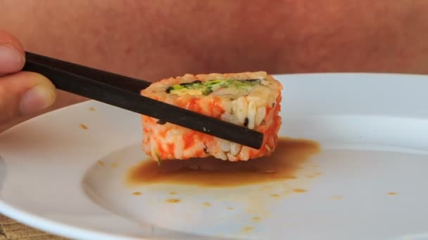 Man pouring sushi roll into souce — Stock Video