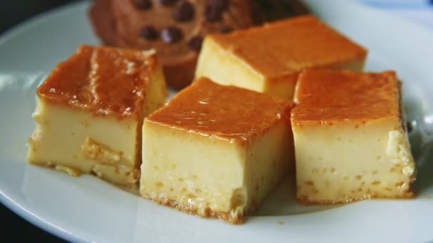 Vista close-up na placa branca com pedaços de bolo de flan de caramelo e biscoitos de chocolate — Vídeo de Stock