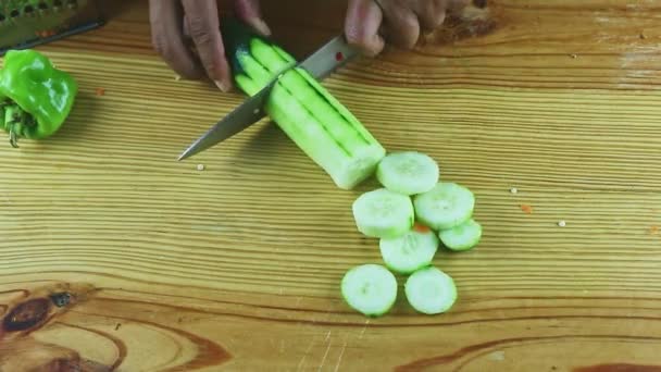 Vue de dessus sur les mains de l'homme coupées par un gros couteau grand concombre vert mûr en morceaux — Video
