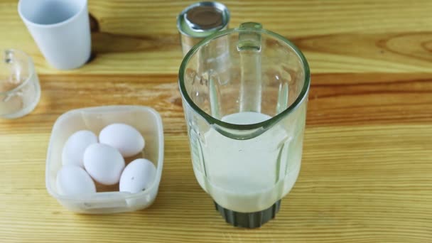 Bovenaanzicht op mens door handen open klein blik met gecondenseerde melk naast blender kelk — Stockvideo