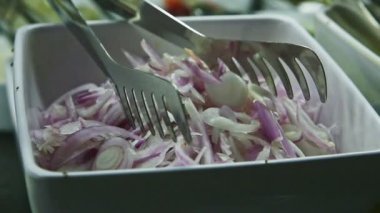 Beyaz tabaktan mor soğan salatasına ve büyük havuç salatasına kadar yakın plan panorama.