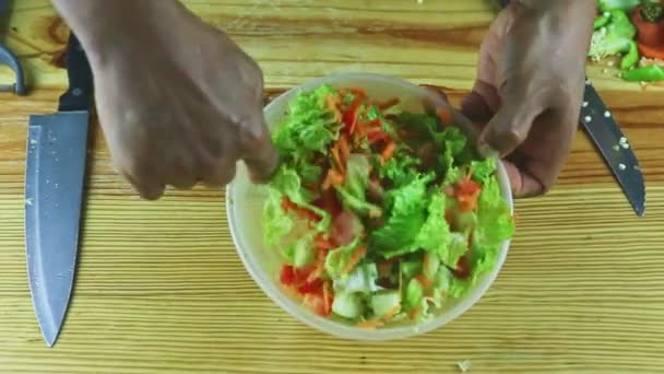 Top view closeup man hands by spoon Ανακατέψτε τα λαχανικά σε φέτες σαλάτα σε μεγάλο πλαστικό μπολ — Αρχείο Βίντεο