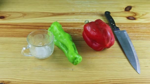 Közelkép közelről közelít csoport piros és zöld paprika, nagy kés és csésze tengeri só — Stock videók