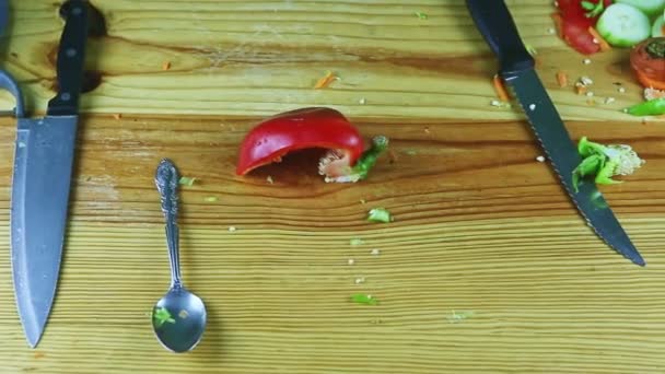 Büyük bıçaklar ve dilimlenmiş sebze artıklarıyla ahşap masada yavaşça panorama. — Stok video