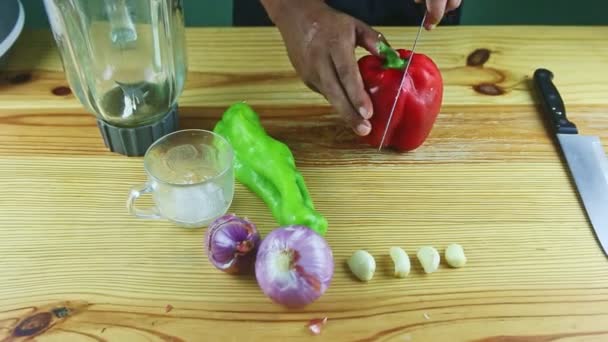 Ovanifrån på människohänder ta stora röda mogna paprika och skär den på halvor med kniv — Stockvideo