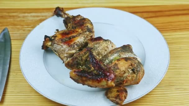 Perlahan-lahan zoom out dari setengah dari dipanggang di herbal ayam pada piring putih bulat — Stok Video
