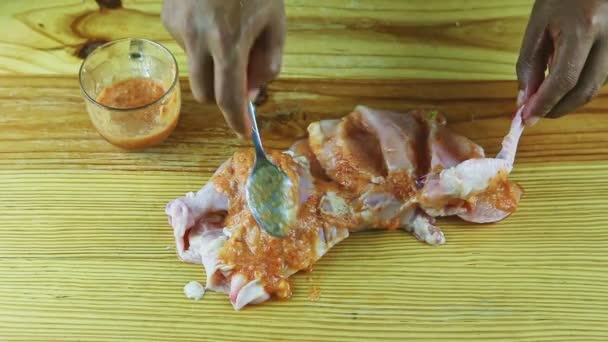 Vue de dessus sur l'homme mains par cuillère mariner la moitié du poulet cru avec de la sauce à l'ail — Video